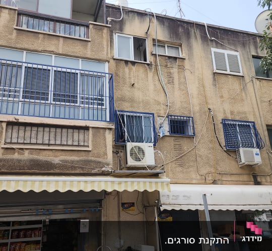 מעקות ברזל כחולים על חלונות ומרפסת
